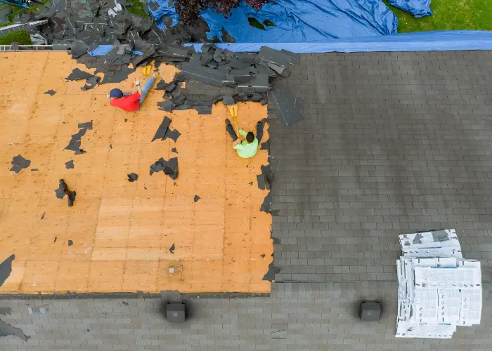 Roofing workers removing an old roof prior to doing a new roof replacement