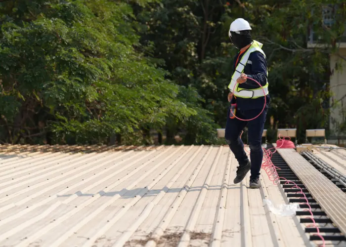 A roofing worker doing a pre-maintenance roof inspection