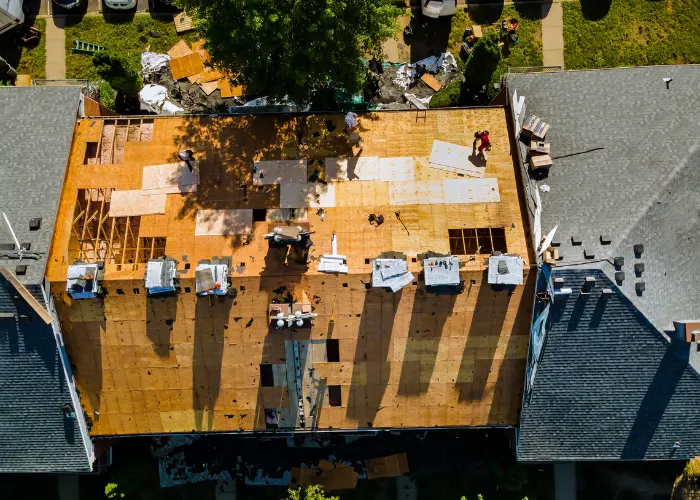 roofing workers laying underlayment in preparation for a new roof installation